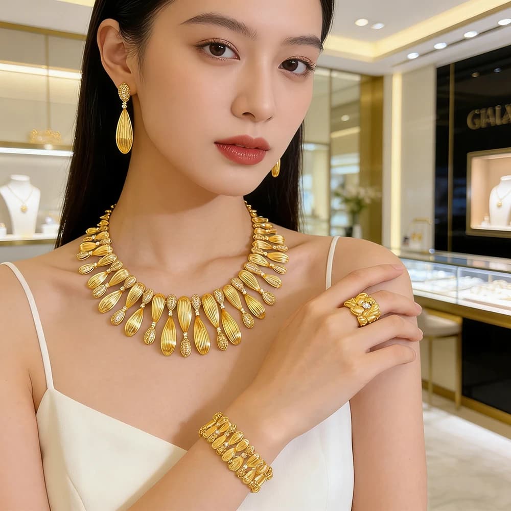 Collection de bijoux en or d'inspiration vintage : collier floral superposé, boucles d'oreilles pendantes, bracelet et bague – Luxe ethnique intemporel